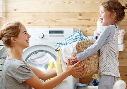 A mom and daughter remove clean, soft laundry from the dryer with the caption "Clean Water for Your Whole Home".