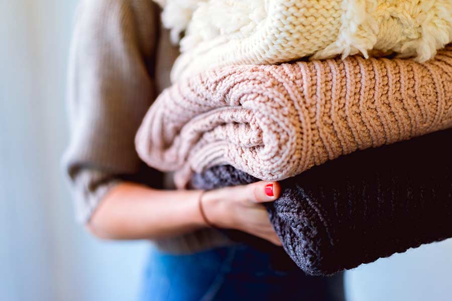 Woman holding a stack of laundry