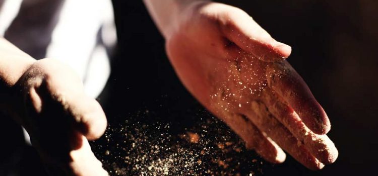 Person's hands clapping and stirring up dust