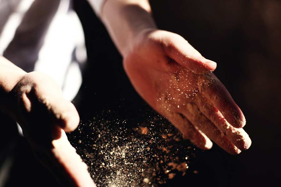 Person's hands clapping and stirring up dust