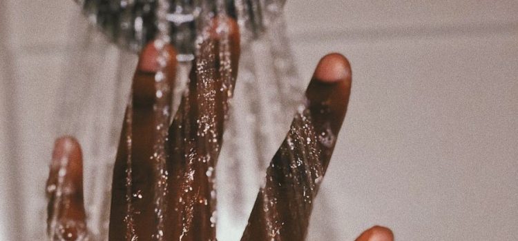 hand under showerhead feeling water that has been through Water Filtration, Conditioner, and Treatment in Austin, Tx Texas