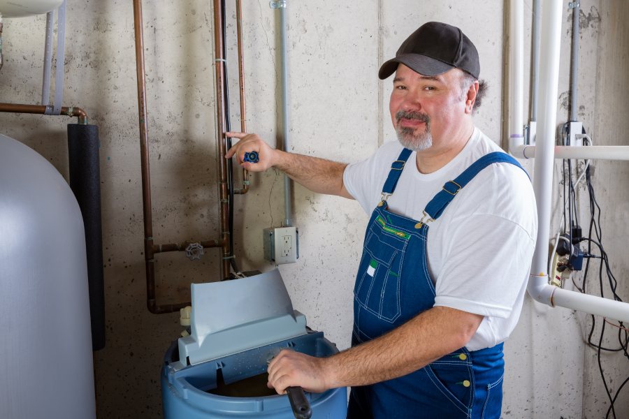 friendly man working on a water softener install in someones garage