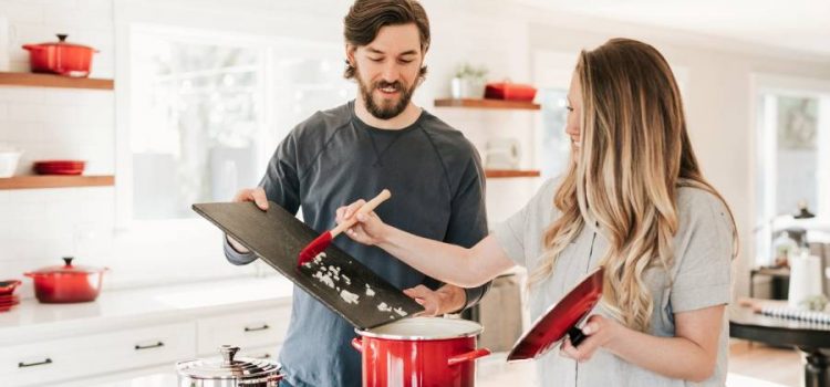 Couple in kitchen cooking with a gas stove