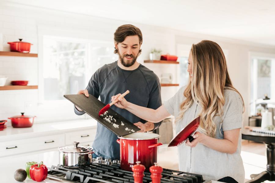 Couple in kitchen cooking with a gas stove