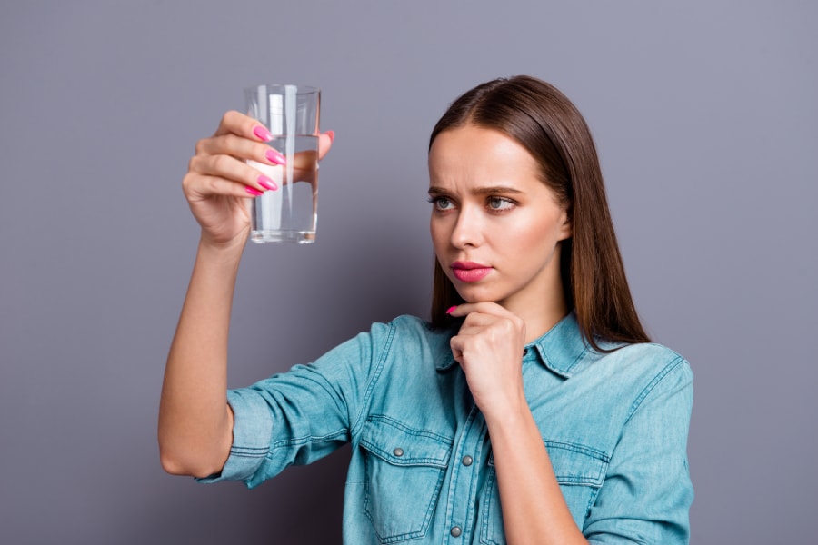 Woman testing water quality for contamination, emphasizing the importance of water filtration in Georgetown