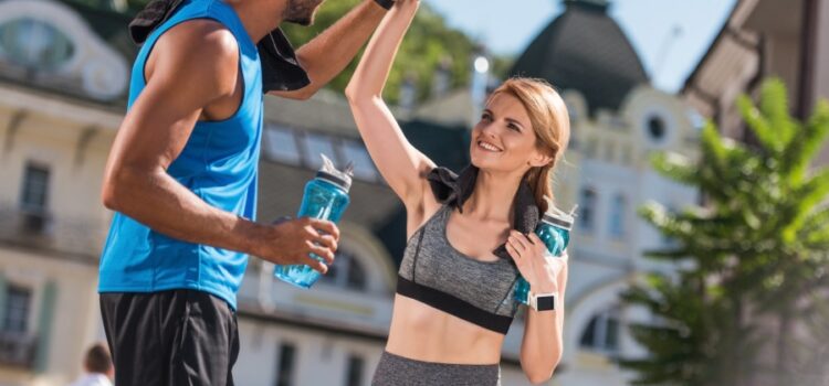 Happy couple rehydrating after a workout with dripping springs reverse osmosis water