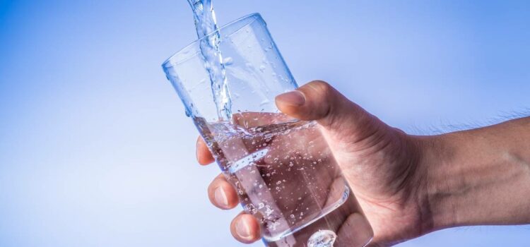 Pouring purified water from Round Rock water filters into a glass