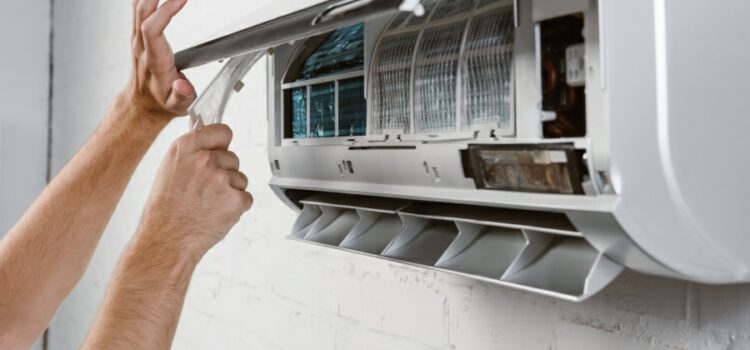 Technician performing routine cleaning on air conditioner filters for dust allergy prevention in Round Rock